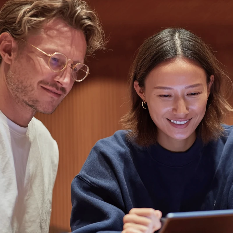 Two colleagues reviewing content on a tablet