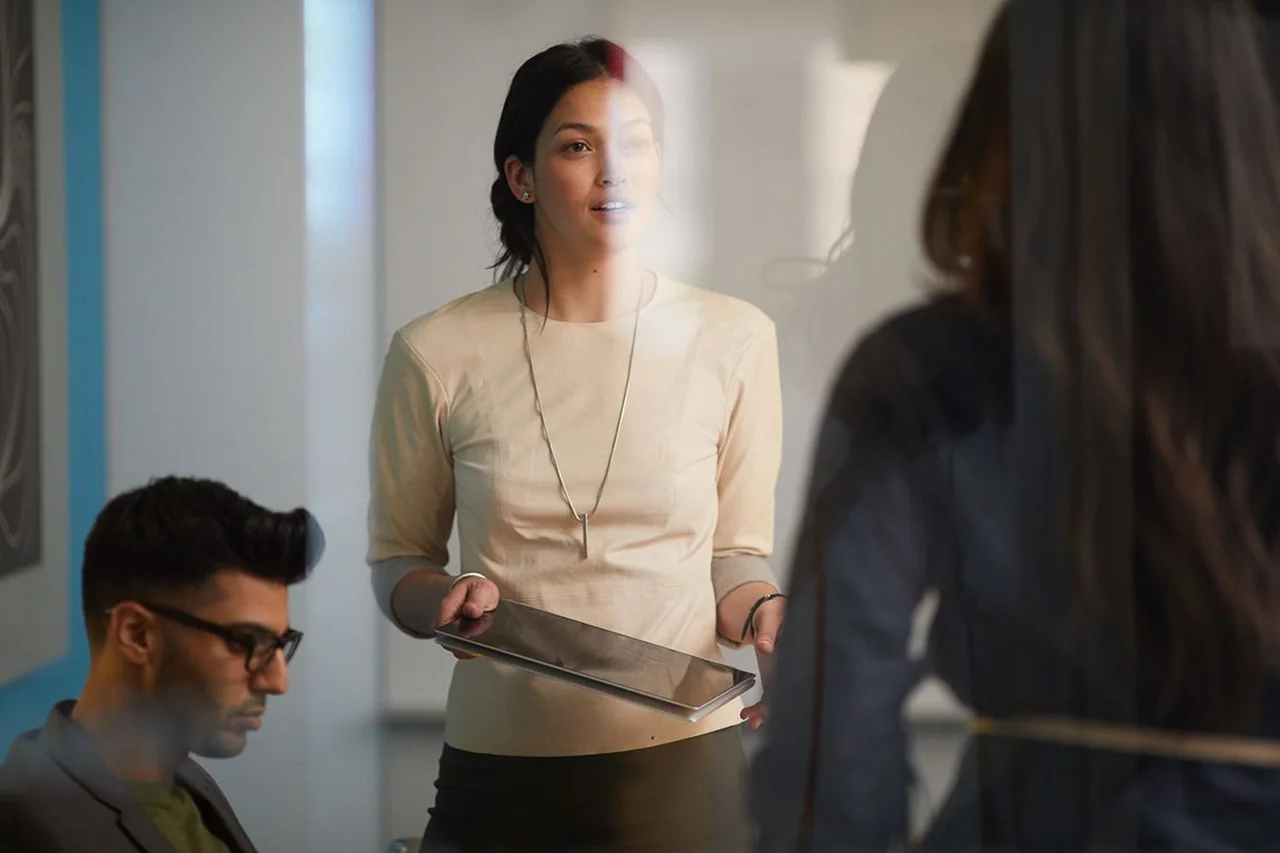 Strategist presenting on tablet to colleagues